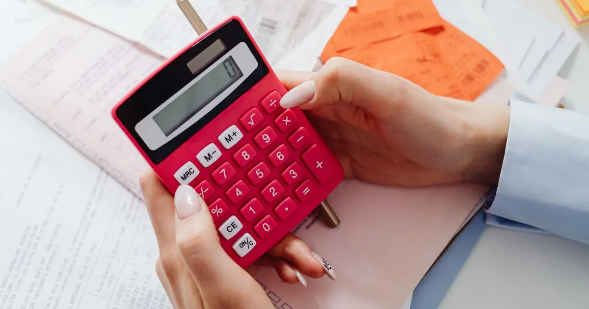 Adding up payday loan costs Canada caps allow with a calculator and receipts