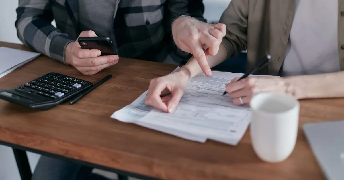 Couple working through a payday loan repayment plan with paperwork and a calculator