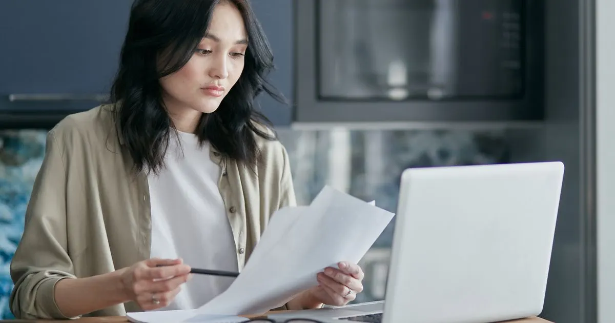 Woman reading the fine print of a payday loans no refusal Canada ad on her laptop