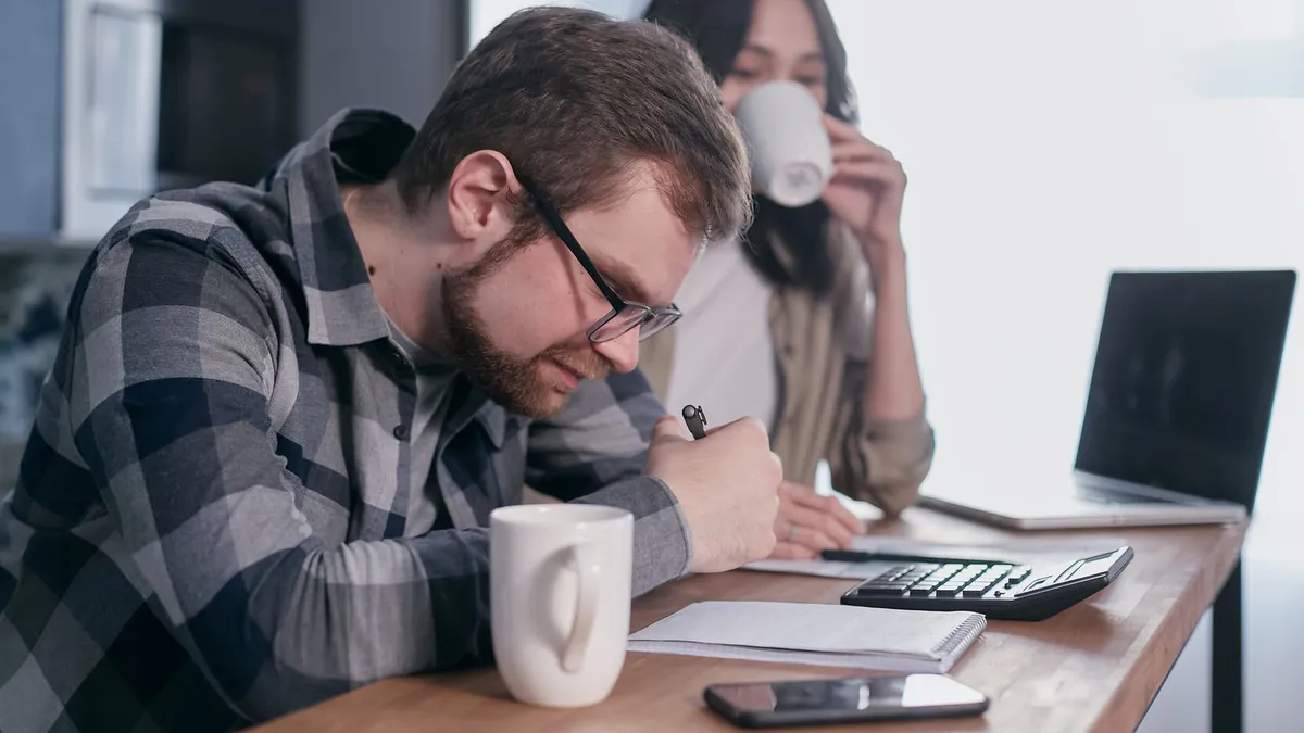 Couple working out whether a guaranteed payday loans offer adds up at the kitchen table