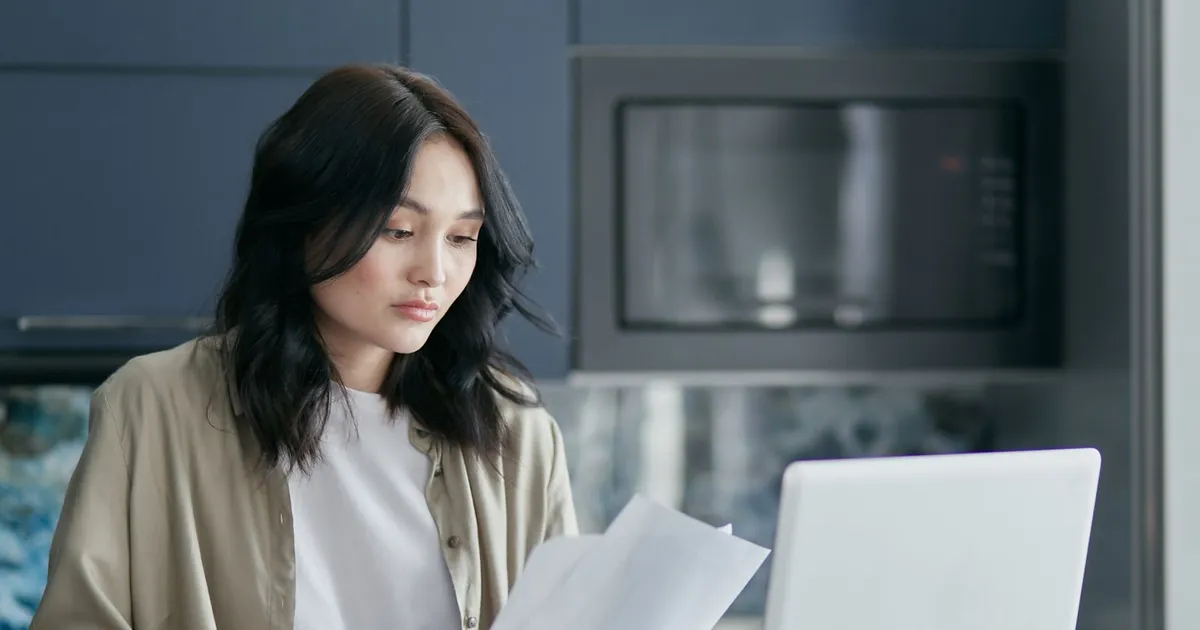 Woman reading a guaranteed payday loans offer at her kitchen table in Canada