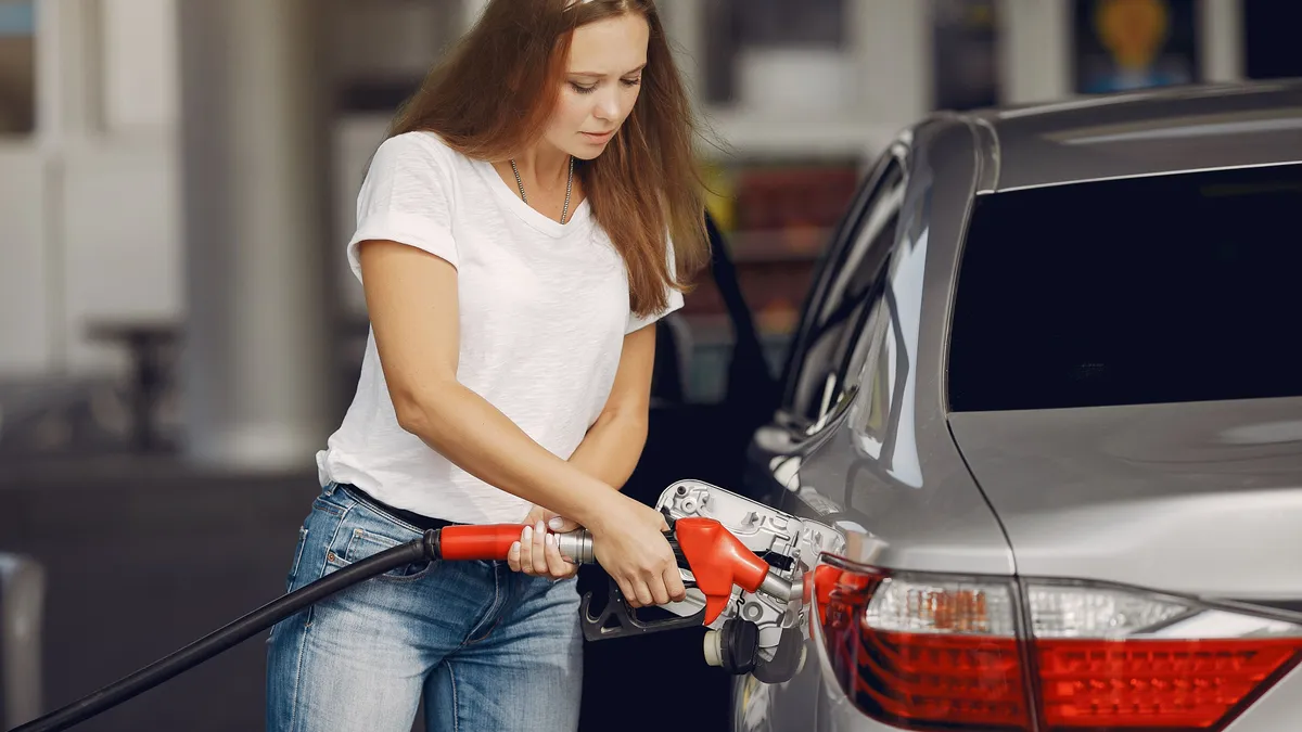 Driver filling her tank at a gas station, the tank of gas to get to work that a $100 payday loan is most often asked for